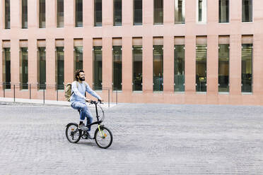 Lächelnder Mann beim Radfahren in der Stadt - XLGF02973