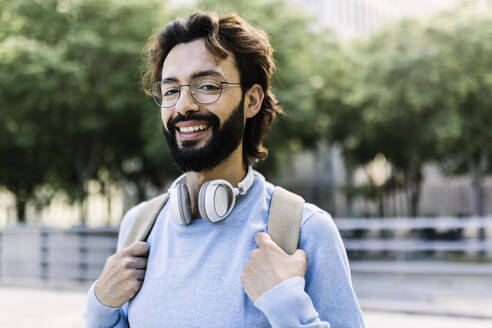 Glücklicher bärtiger Mann mit kabellosen Kopfhörern - XLGF02983