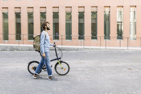 Mann mit Fahrrad auf einer Straße in der Stadt - XLGF03020