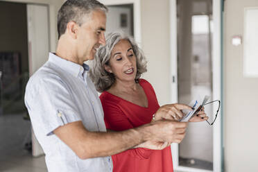 Happy businessman with businesswoman discussing at office - JCICF00254