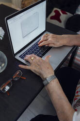 Hands of senior woman using laptop at home - EGHF00464