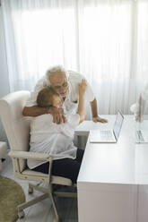 Glücklicher älterer Mann umarmt seine Mutter zu Hause - EGHF00470