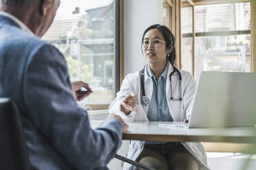 Arzt im Gespräch mit einem Patienten in einer medizinischen Klinik - UUF26635