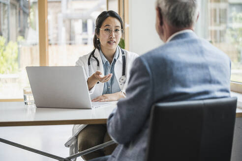 Ärztin im Gespräch mit einem Patienten in einer medizinischen Klinik - UUF26660