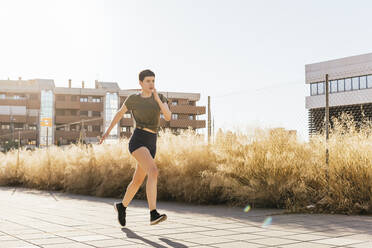 Woman running on footpath - MGRF00689
