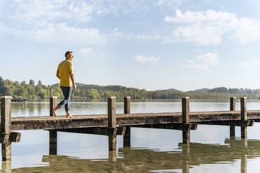 Man walking on pier at lake - DIGF18154
