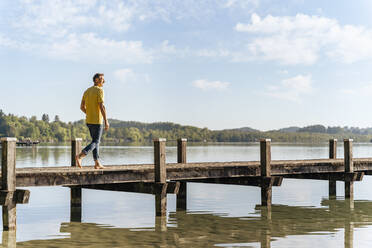 Mann geht auf Pier am See - DIGF18154