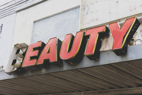 Old BEAUTY sign in front of abandoned department store, red lettering. - MINF16544