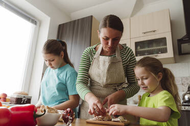 Mutter hilft Tochter bei der Zubereitung von Pizza zu Hause - OSF00173