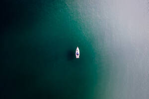 Aerial view of a lone motor boat sailing in the sea near Sagres, Algarve region, Portugal. - AAEF14780