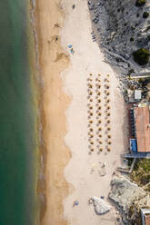 Luftaufnahme von Sonnenschirmen am Strand ohne Menschen im Sommer in der Algarve-Region, Portugal. - AAEF14782