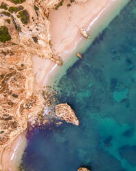 Luftaufnahme von oben auf die wilde Küste in der Nähe von Praia da Marinha mit kleinen paradiesischen Stränden bei Sonnenaufgang, Lagoa, Algarve-Region, Portugal. - AAEF14794