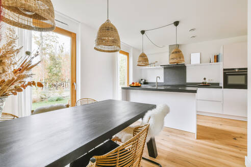 Contemporary counters with sink located in middle of light kitchen with dining area in daytime at home - ADSF35568