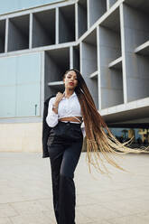Selbstbewusste junge Geschäftsfrau mit langen braunen geflochtenen Haaren - JRVF03018