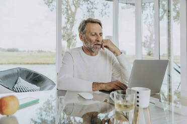 Freiberufler arbeiten mit Laptop zu Hause - MFF09189