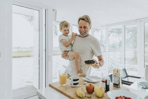 Glücklicher Vater mit Sohn beim Frühstück zu Hause - MFF09243