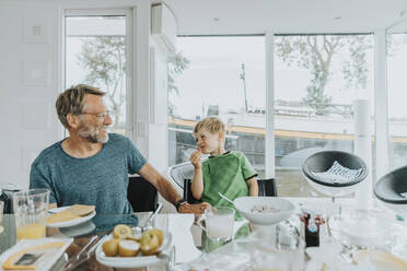 Glücklicher Vater und Sohn beim Frühstück am Esstisch - MFF09252
