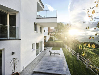 Österreich, Tirol, Außenansicht eines modernen Hauses auf einer Anhöhe mit Sonnenuntergang im Hintergrund - CVF02015
