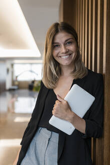 Lächelnde Geschäftsfrau mit Tablet-PC in der Hotellobby - JRVF03045