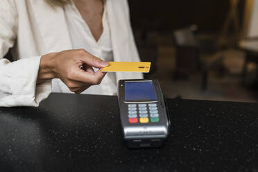 Hand einer Geschäftsfrau beim Bezahlen mit Kreditkarte im Restaurant - JRVF03125