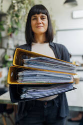 Businesswoman holding files in office - MEUF06656