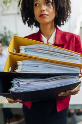 Businesswoman holding file folders in office - MEUF06661