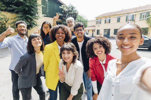 Smiling multiracial colleagues taking selfie on sunny day - MEUF06692