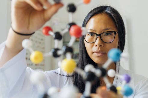 Scientist examining DNA model in laboratory - MEUF06695