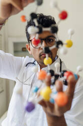 Junge Wissenschaftlerin bei der Untersuchung eines Helixmodells im Labor - MEUF06701
