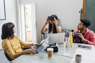 Geschäftsfrau trägt VR-Brille bei multiethnischen Kollegen im Büro - MEUF06722