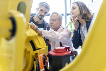 Techniker untersuchen Industrieroboter in einer Fabrik - WESTF24838