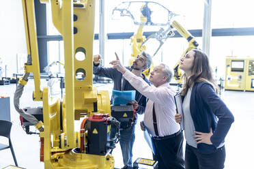 Techniker untersuchen Industrieroboter in einer Fabrik - WESTF24841