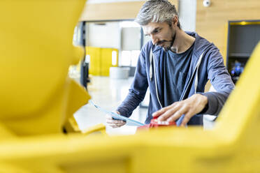 Technician inspecting industrial robot in factory - WESTF24842