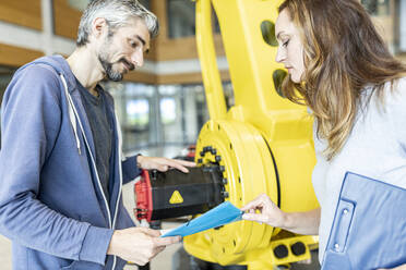 Techniker bei einer Besprechung vor einem Industrieroboter - WESTF24856