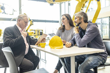 Mitarbeiter bei einer Besprechung mit dem Chef in einer industriellen Fabrik - WESTF24867