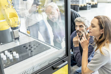 Technicians testing and observing new industrial robot - WESTF24874