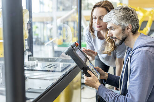 Ingenieure testen Industrieroboter in Glaskabine - WESTF24880