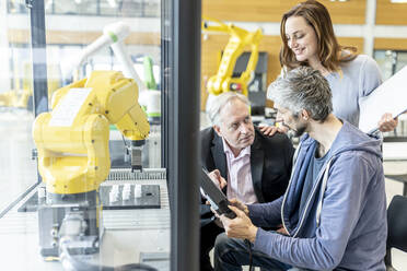 Senior customer getting advise on industrial robot from expert staff - WESTF24884