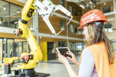 Facharbeiter steuert Roboterarm mit digitalem Tablet - WESTF24901