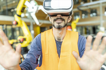 Industriearbeiter in einer Roboterfabrik mit einem Simulator der virtuellen Realität - WESTF24917