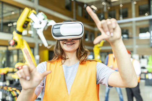 Industriearbeiter in einer Roboterfabrik mit einem Simulator der virtuellen Realität - WESTF24921
