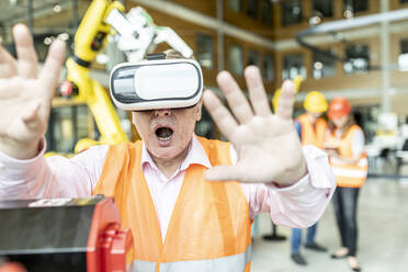 Industriearbeiter in einer Roboterfabrik mit einem Simulator der virtuellen Realität - WESTF24923