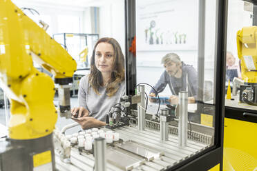 Woman working in robotic factory using digital tablet - WESTF24927