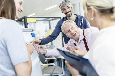 Group of business people discussing presentation of female colleague - WESTF24945