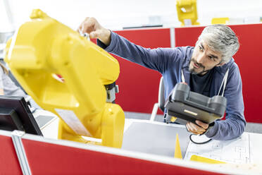 Industrial engineer working at industrial robot using digital control - WESTF24950