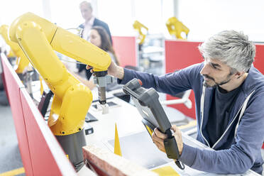 Industrial engineer working at industrial robot using digital control - WESTF24951