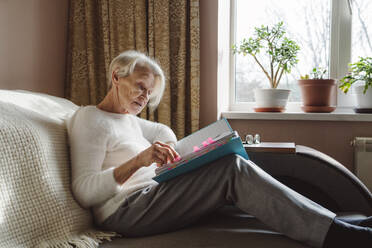 Ältere Frau liest Dokumente zu Hause - OSF00197