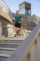 Junger Mann joggt auf einer Treppe - DIGF18217