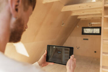 Mann nutzt Tablet-PC zur Visualisierung der Inneneinrichtung eines neuen Öko-Holzhauses - OSF00234