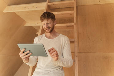 Mann beim Einrichten einer Smart-Home-Einheit mit digitalem Tablet im Öko-Haus - OSF00239